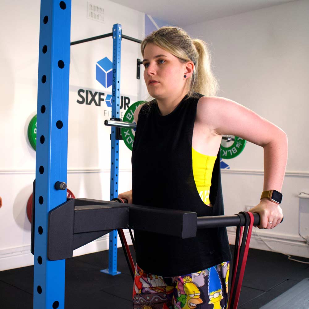 A woman performing dips with focus during a small-group session